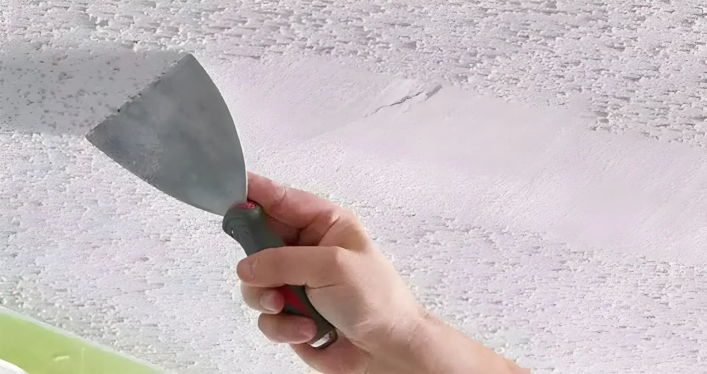 Los Pintores Alicante eliminando el gotelé con espátula para dejar la pared lisa